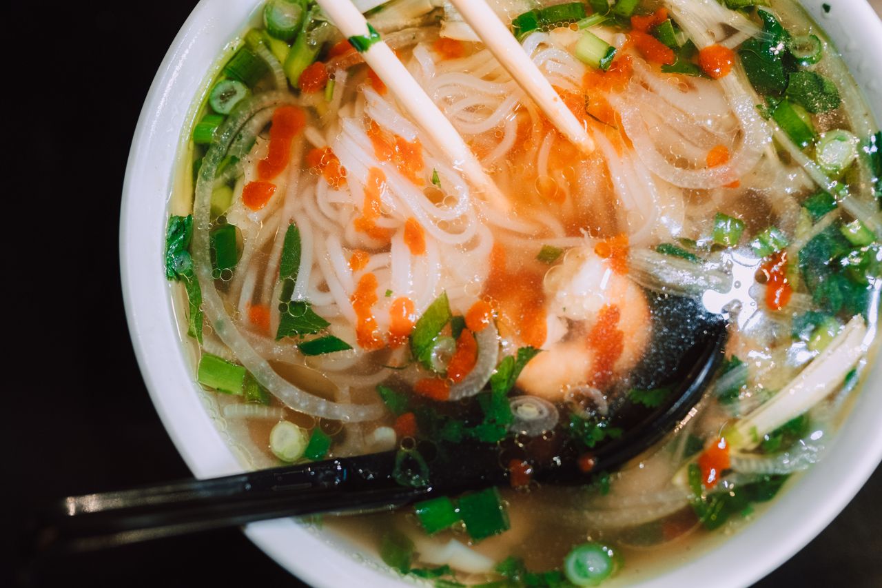 Delicious Asian noodle soup with vibrant garnishes captured in a close-up shot.
